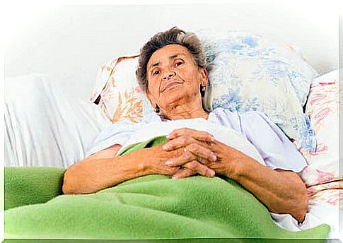 A woman with Alzheimer's is lying in bed