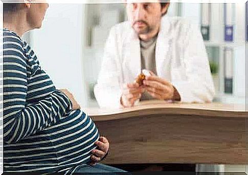 A pregnant woman talking to her doctor about medication.