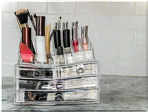 A makeup organizer with makeup and brushes.