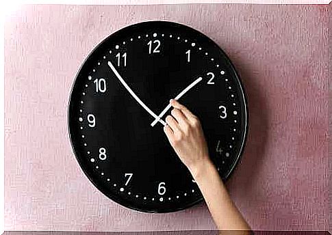 A person adjusting a clock.