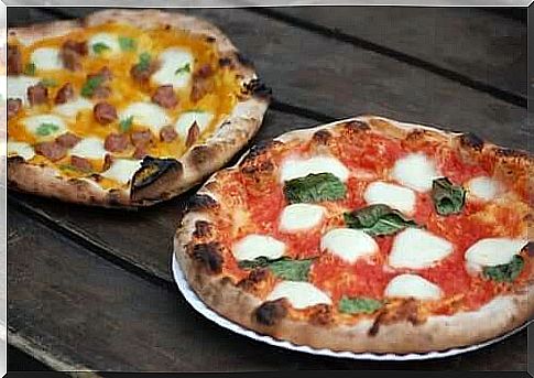 Two Neapolitan-style pizzas on plates.