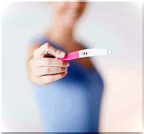 A woman showing a positive pregnancy test.