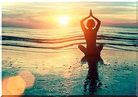 a woman meditating on the beach