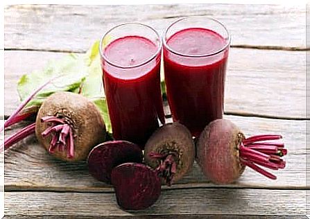 Beetroot juice in two glasses with fresh beets next to it